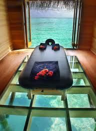 A massage hut in Bali overlooking the crystal waters, clear glass floor to watch