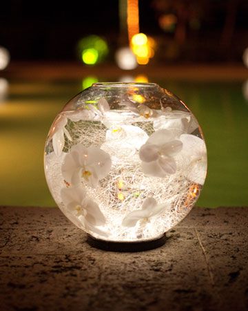 Glass globes filled with water, silver thread and orchid heads are placed on LED