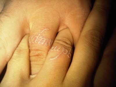 Matching white ink ring finger tattoos, Que Quieres De Mi Vida (what do you want