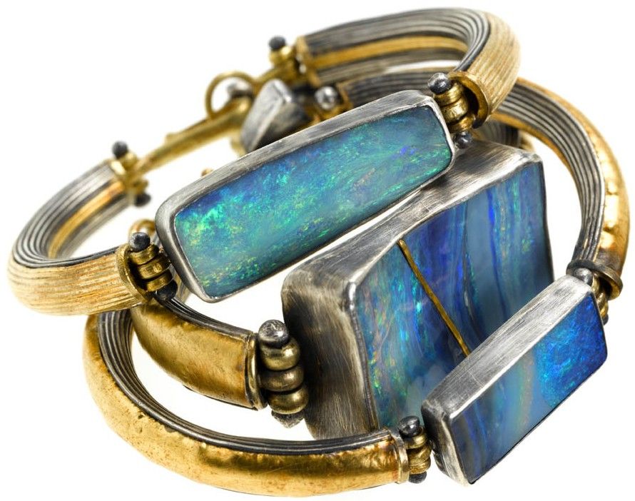 Opals set in bracelets with silver and gold by Judy Geib. Look close at the repa