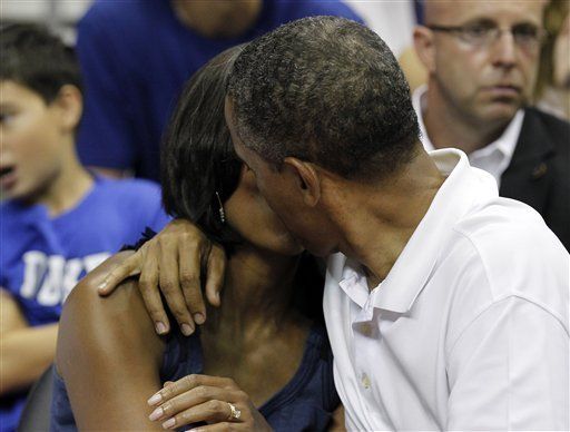 President Barack Obama, right, kisses first lady Michelle Obama for the 'Kis
