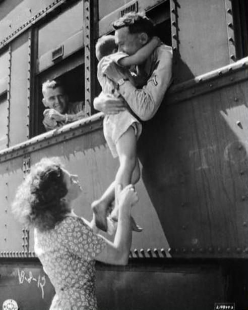 Wife of a departing soldier lifts her son for farewell embrace. Oklahoma, 1945.