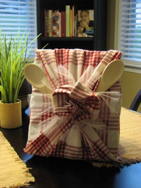 A fun wedding gift! A cookbook wrapped in dish towels and wooden spoons!