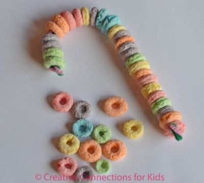 Cereal Candy Cane Tree Decoration- Child strings cheerios or fruit loops onto pi