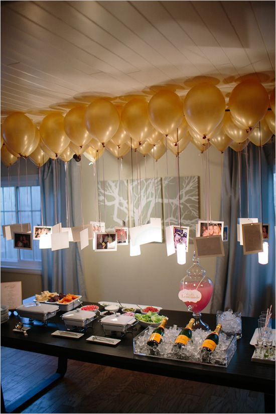 photos hanging from balloons to create a chandelier over a table.