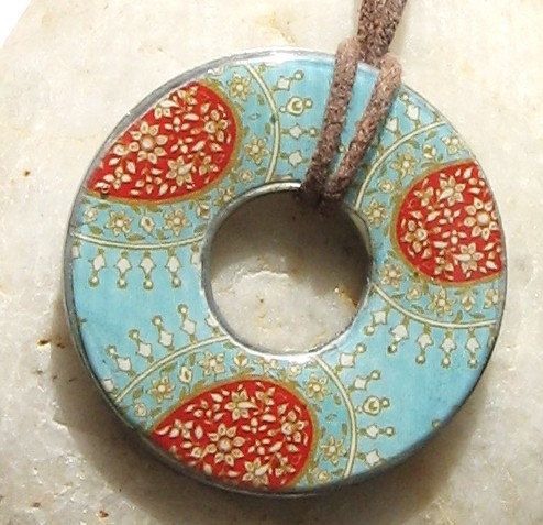 A pendant made from a washer, scrapbook paper, and mod podge.