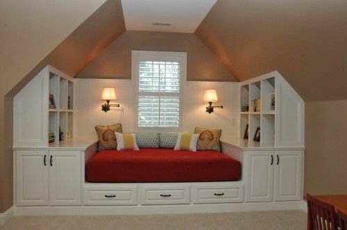 Great way to use bonus area with sloped ceilings! Custom built ins and daybed.