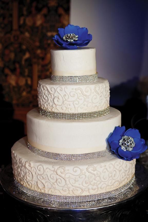 White wedding cake with bling and blue flowers