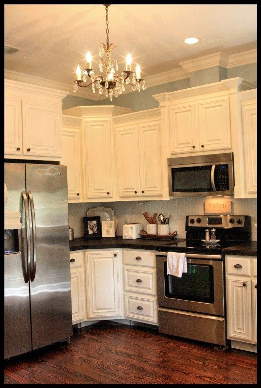 white cabinets and dark floors, stainless, and chandelier