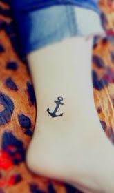 A small anchor tattoo on the ankle saying refuse to sink