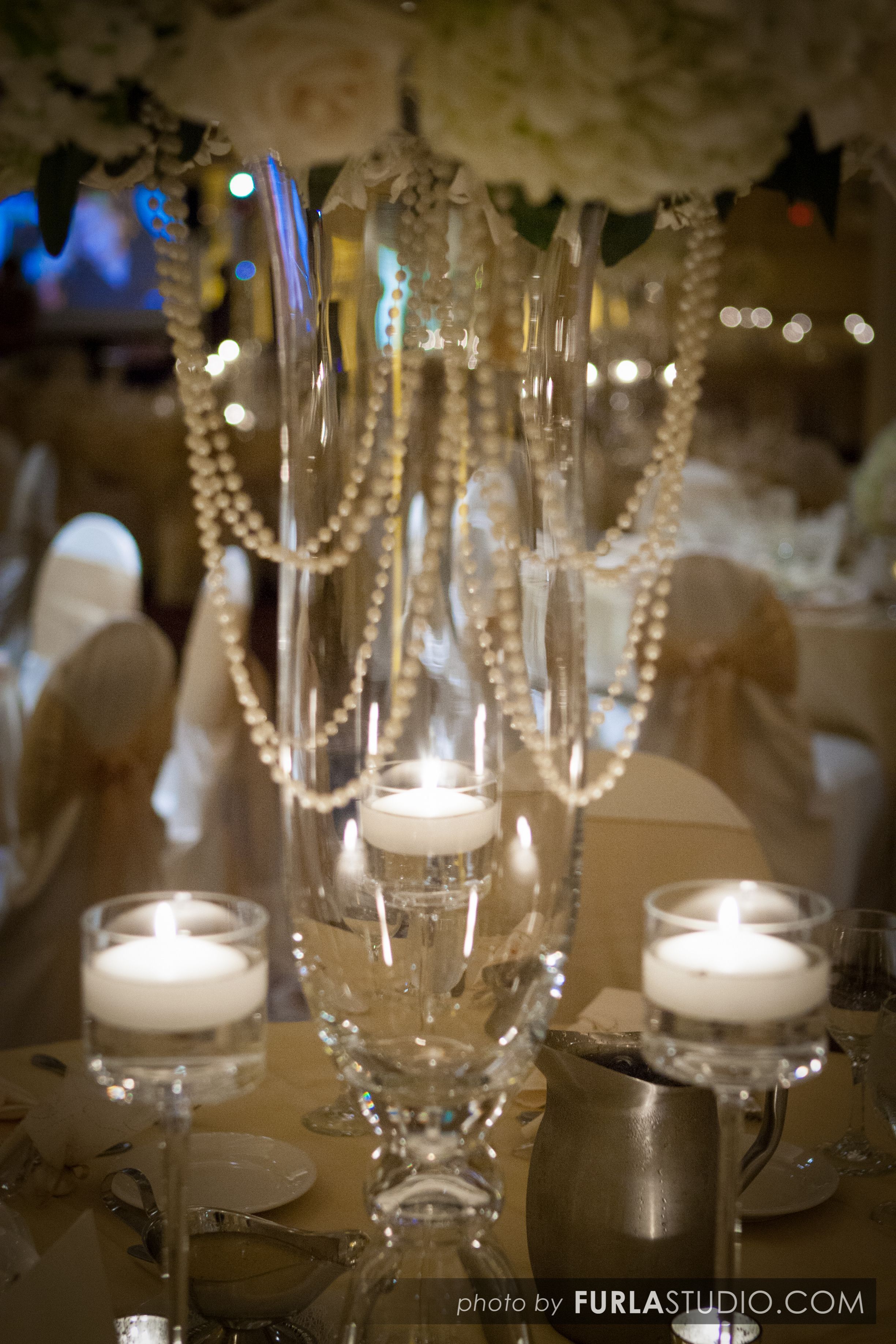 Accents of white hanging pearls add zest to this high table centerpiece. Floatin