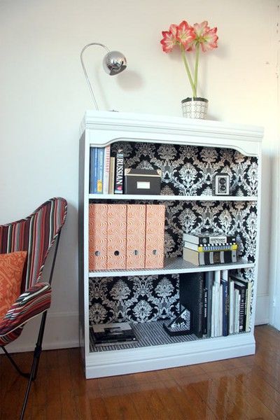 Fancy up a regular bookshelf with wallpaper on the inside.Very cute idea.