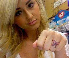bow on finger tattoo