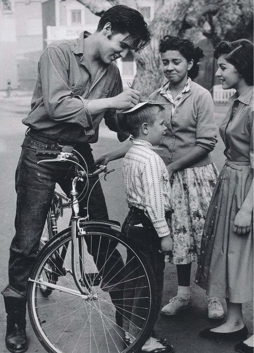 Elvis signing autograph on kids head!