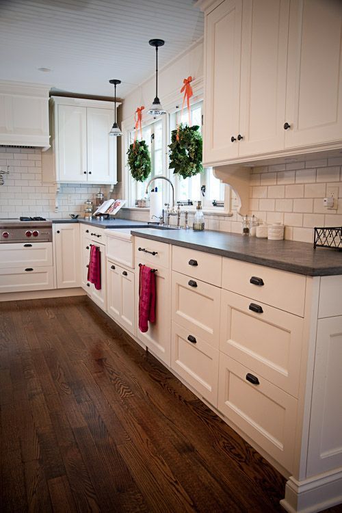 White cabinets honed slate counter tops, and black handles. Love the slate count