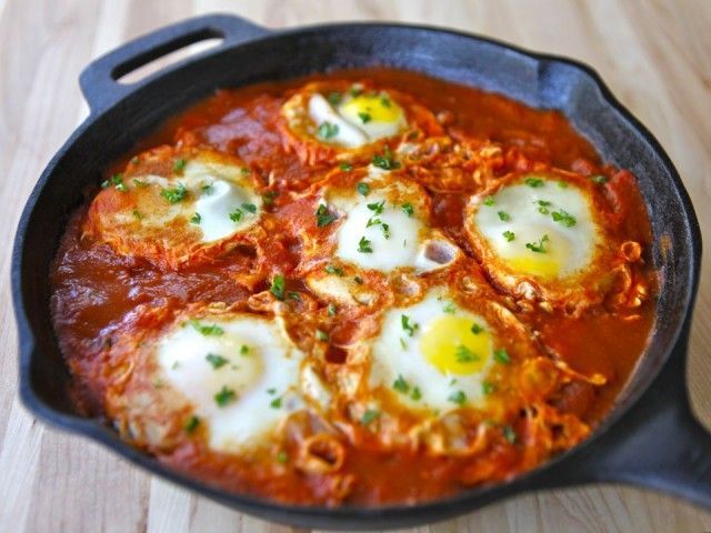 Shakshuka This is a simple, comforting Israeli dish of eggs poached in spicy tomato sauce. To make it, I sautee onions, garlic, and peppers in olive oil with cumin, paprika, salt, and pepper,