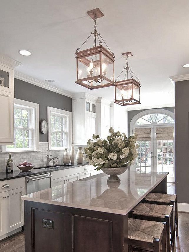 grey walls, white cabinets, chrome fittings,grey countertop….rose gold lanterns over walnut island