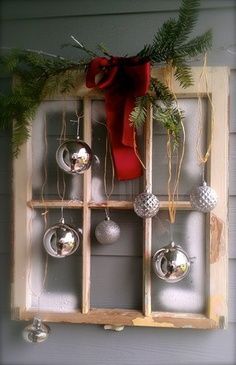 Christmas window idea with window pane, red bow, silver ornaments. I think this would be a great front door wreath for a house in