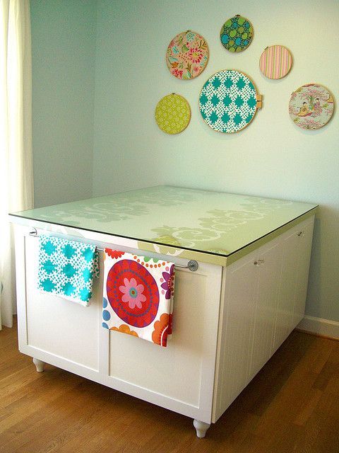 Craft Room Sewing Table: Hm, a towel bar on the end of the cutting table to hold fabric. I like that idea. BB
