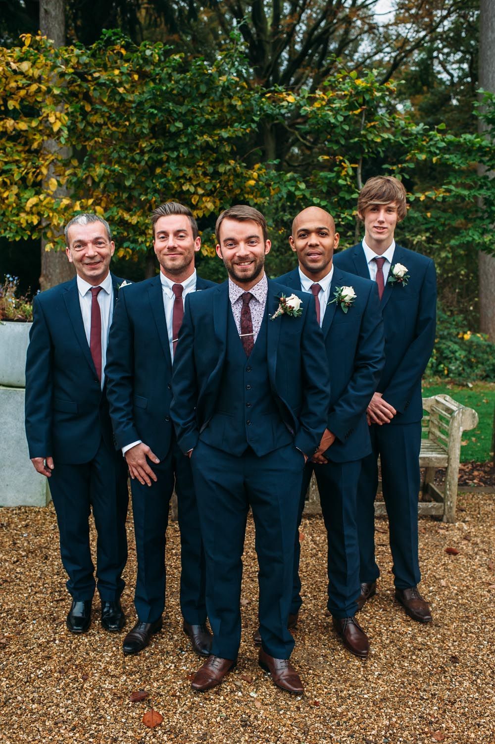 Groomsmen in three piece navy suits with maroon ties – Image by Hannah May – Autumnal rustic themed wedding with Navy, Maroon &