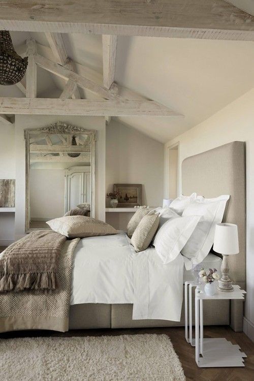 This sleep sanctuary is a combination of browns and greys against a white comforter and pillows.
