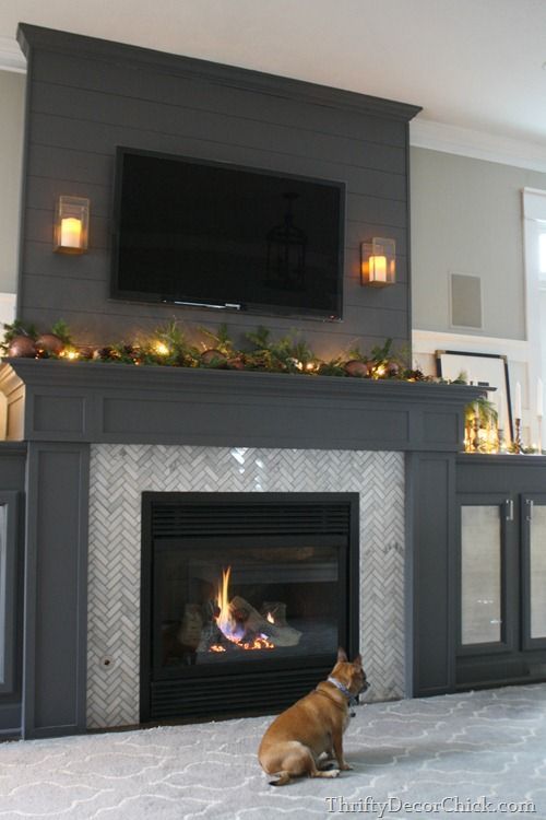 Dark grey built in fireplace with side cabinets.  Love the added height & visual interest with planks of wood above.  Herringbone