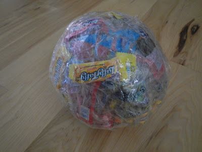 The idea is to use saran wrap & tape to create a ball. As you continue to wrap you add a piece of candy to each layer. Have the