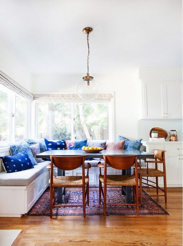 Breakfast nook with indigo Shibori dyed pillows and woven midcentury dining chairs.
