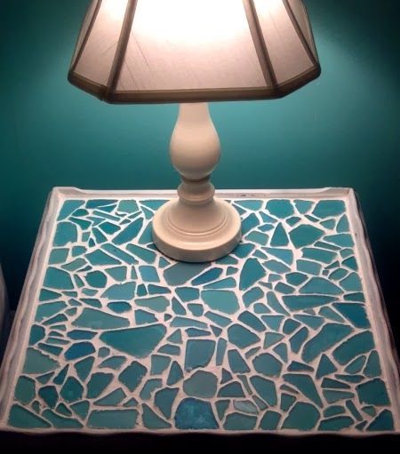 An old table was made over with a sea glass mosaic. The table top was spray-painted white first, then sea glass pieces were