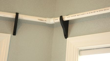 Cheap curtain rod brackets from Lowes and pvc pipe spray painted black. This is what I need in my dining room!
