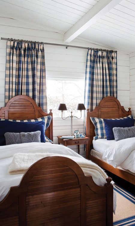 The blue & white color scheme gives a crisp look to this attractive guest room. The stained wood beds keep it from being too light