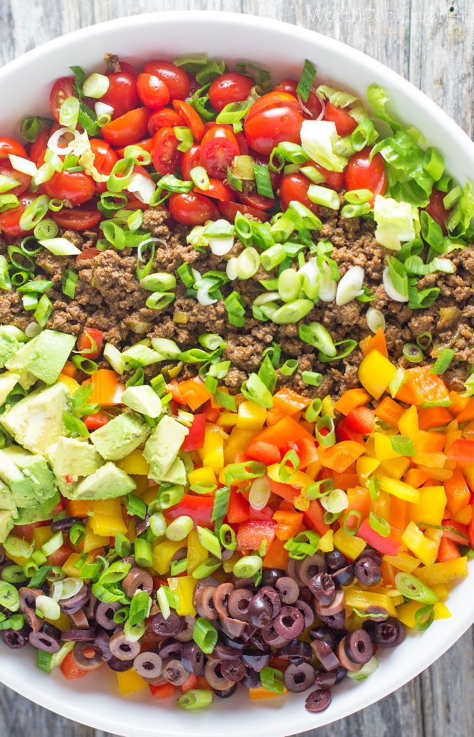 A colorful taco salad full of fresh vegetables, and seasoned meat. Plantain chips add a nice crunch without the corn, and it is