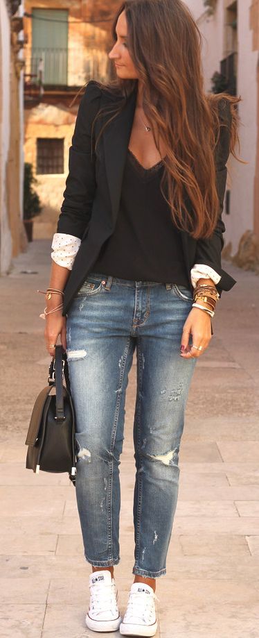 Black blazer over a black blouse with distressed boyfriend jeans and white converse sneakers | Street Style