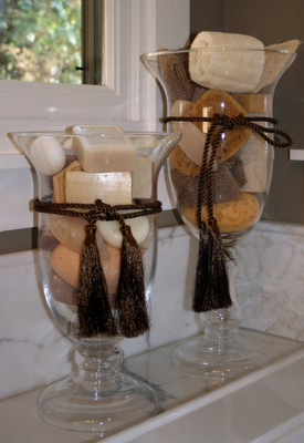 Vases filled with beautiful bath soaps and sponges – like how they vary in height and are finished off with silky dark brown