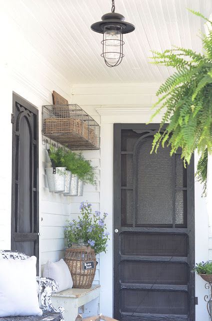 from blog: inspired by charm. Like the black accents, buckets as planters and how high up things are hung.