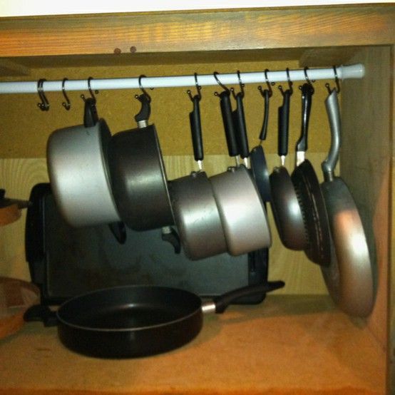 Hang your pans on a curtain rod to eliminate having to lift a heavy stack to get a pan from the bottom. Genius!!