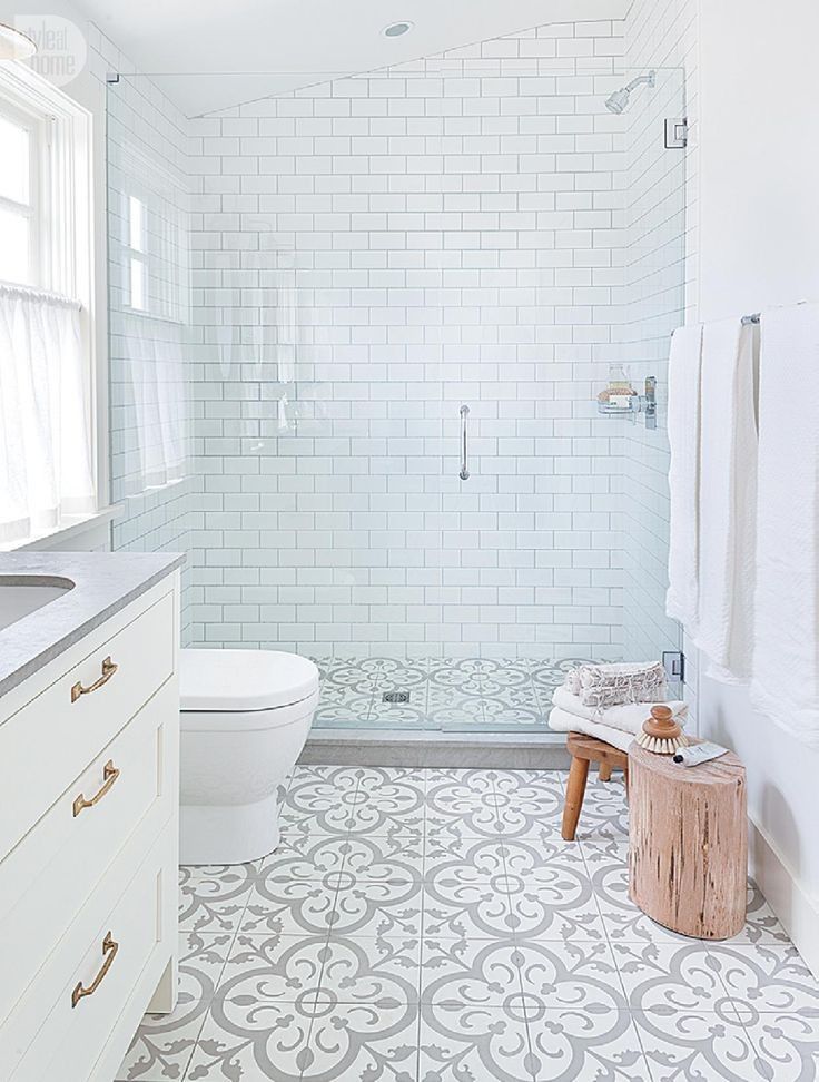 A white bathroom with a patterned tiled floor