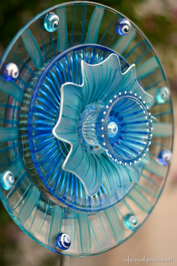 Glass plates from Dollar Tree turned into a bright 3-D flower that catches the sun in your garden!