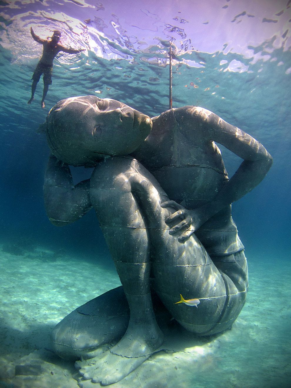 This stunning 18-feet-tall, 60-ton underwater sculpture of Bahamian girl carrying the weight of the ocean