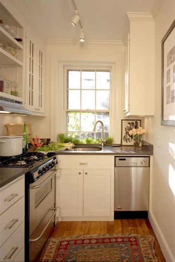 Tiny kitchen. L-shaped. Stainless appliances. Herb window box with sash windows. Gas stove. White cabinets