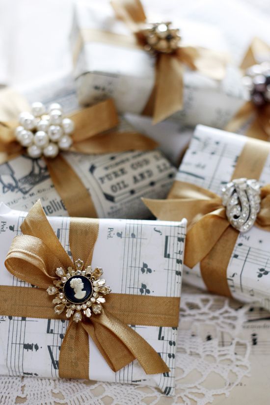 Create an elegant centerpiece with little gift boxes wrapped in vintage sheet music and clippings. Finish
