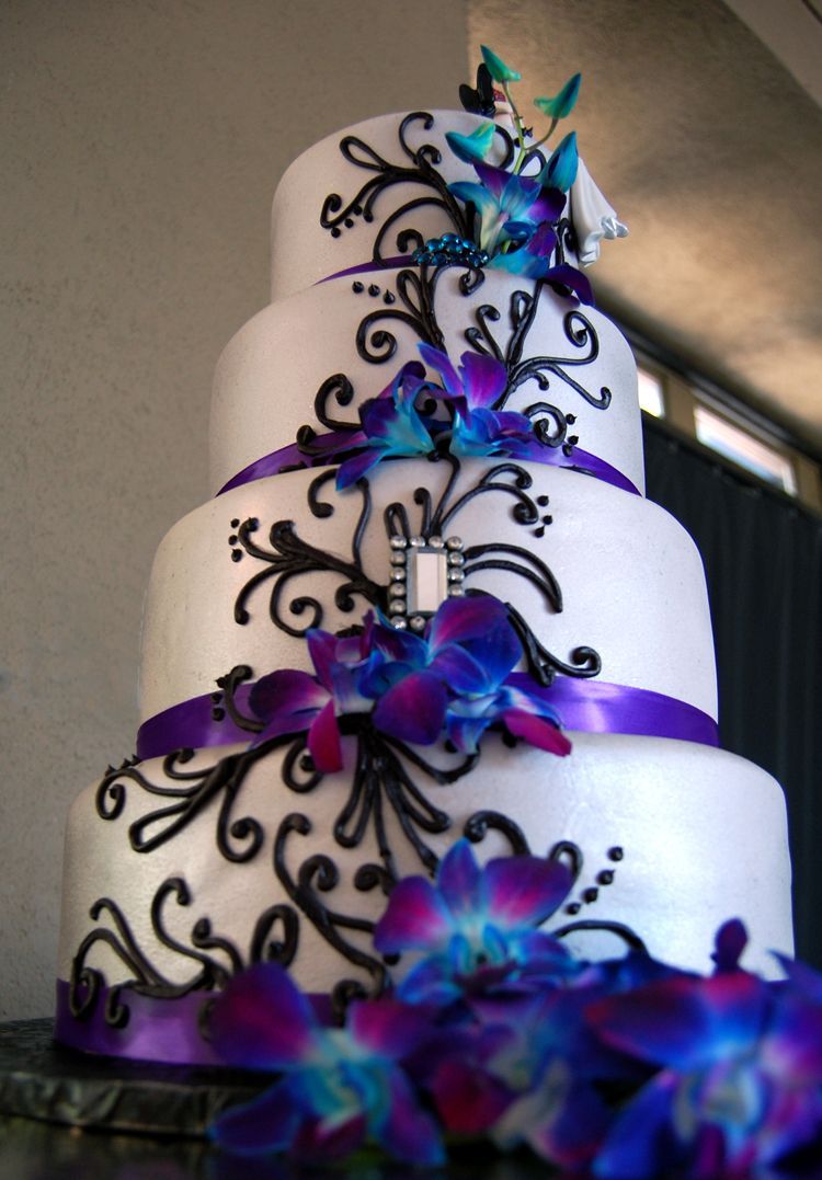 – Fondant wedding cake with purple satin ribbon, black piped scrolls and fresh orchids. The Crafty Cakery,