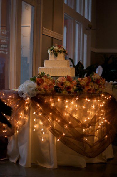 I like the idea of the cake, food, gift and sweetheart table being lighted underneath with ivory table clo