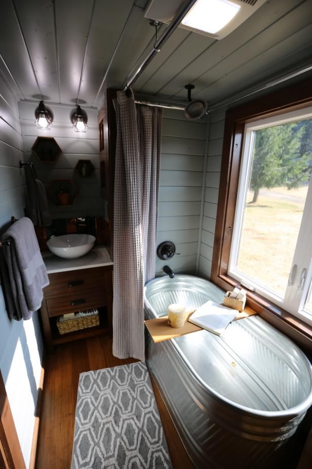 Luxurious tiny bathroom features a full-sized galvanized soaking tub, a relaxing station, spa shower, vess
