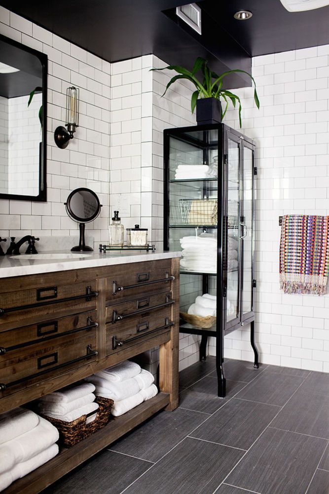 black-and-white bathroom with tiled walls and black grout makes for easy maintenance and lends further hig