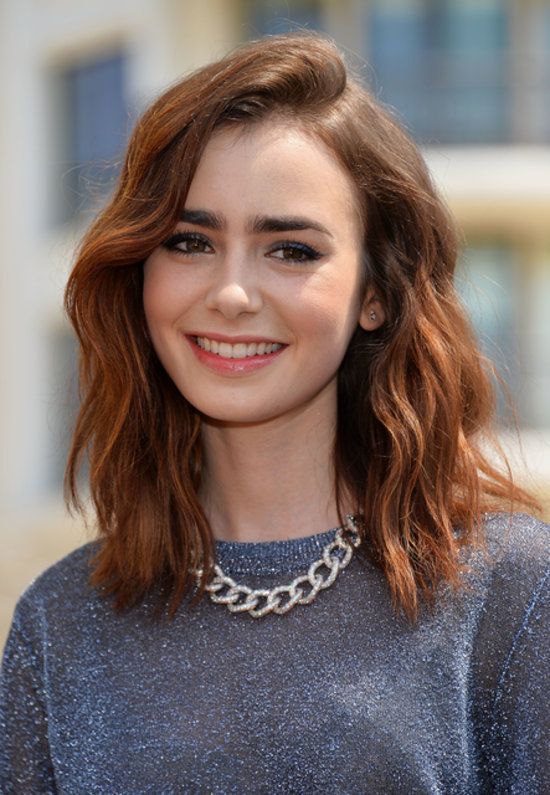 Lily Collins: Lily Collins sweeps her big waves over to one side to add body at the crown and make her mid