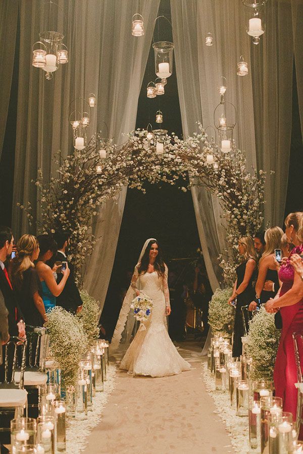 Entrada da cerimônia de casamento com arco de flores e velas