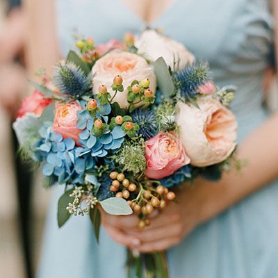 Globe thistle and hydrangeas are stunning blue accents to the peach flowers in this wedding bouquet.
