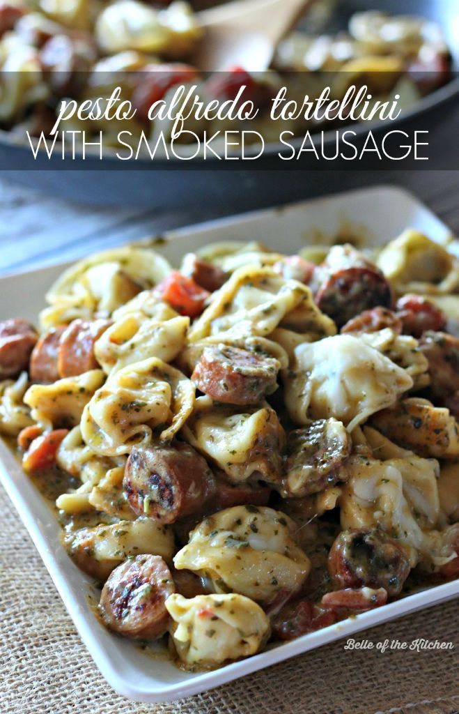 Tortellini with smoked sausage drenched in a creamy pesto Alfredo sauce with tomatoes, garlic, and goo