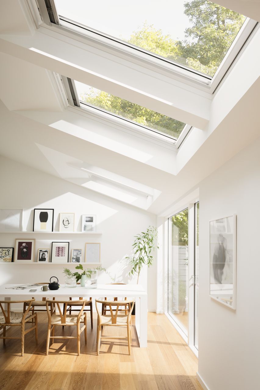 Bright Scandinavian dining room with roof windows and increased natural light.